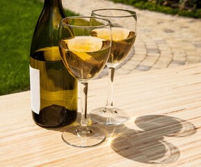 Bottle and glasses of white wine outdoors