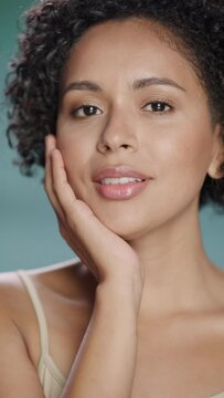 Female Beauty Vertical Portrait. Beautiful Black Multiethnic Latina Woman with Afro Hair Posing, Touching Her Natural, Healthy Skin. Wellness and Skincare Concept on Soft Isolated Background. Close Up
