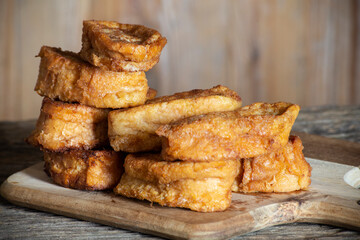 pile of French toast on a wooden board. selective focus. torrijas