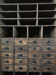 Schöner alter Apothekerschrank aus Holz mit Schubladen in Braun in einer ehemaligen Fabrikhalle im...