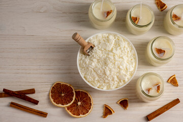 Set for crafting candle on wooden background. Eco soy wax on white table. DIY candle. Hobby concept.