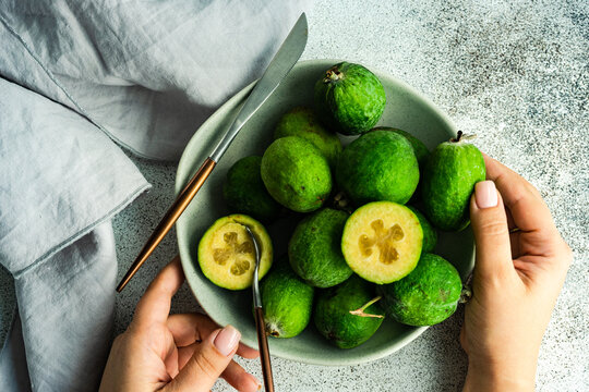 Woman eating a ripe organic feijoa fruit