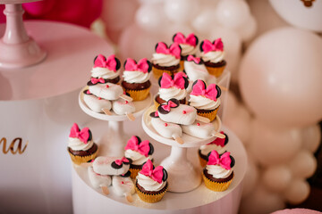 A beautifully arranged display of cupcakes decorated with pink bows for a special event.