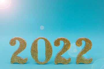 Happy new year 2022 gold color with blue background and flash of light