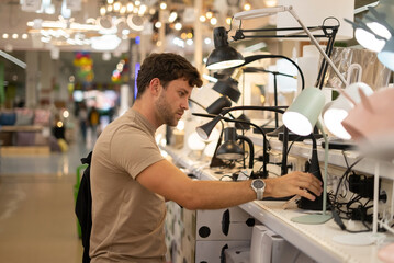Male shopper choosing lamp in mall