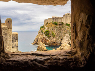 Looking through stone portal out onto old fortress and Adriatic Sea in Dubrovnik, Croatia.