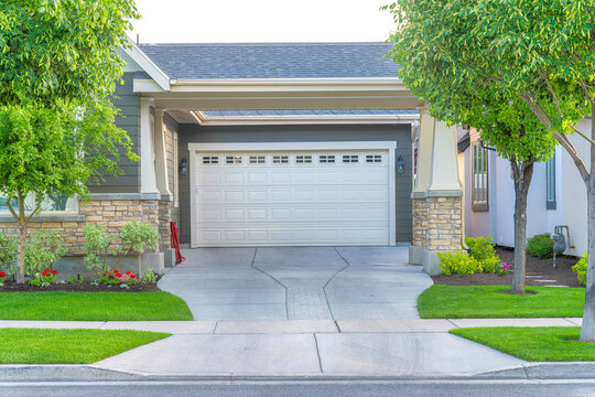 Garage of a house with concrete driveway intersecting with the sidewalk at Daybreak, Utah
