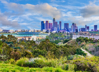 Skyscrapers of Los Angeles skyline are surrounded by green hills, CA