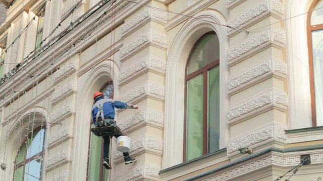 worker builder high-rise restores a historic building fasade .concept job