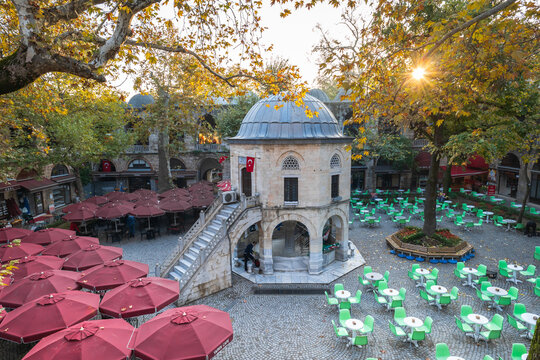 Bursa, Turkey - October 2021: Koza Han tea gardens and mosque in Koza Han Silk Bazaar. Koza Han is historical place from Ottoman times in Bursa, Turkey, and a popular tourist attraction.