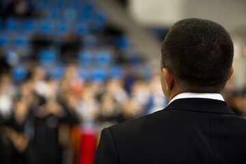 Speaker at Business Conference with Public Presentations. Audience at the conference hall. Entrepreneurship club. Rear view. Horisontal composition. Background blur.