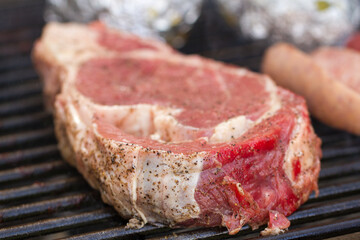 Closeup to a seasoned raw beef steak with salt and pepper