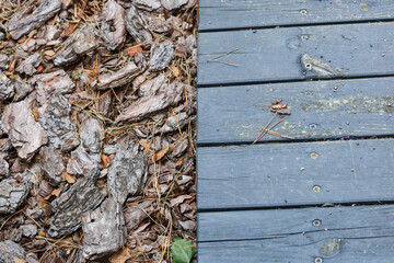 Wooden flooring near the green leaves, pine needles, stones. High quality photo