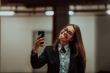 An attractive business woman in glasses using a smartphone. Selective Focus. Business Portrait