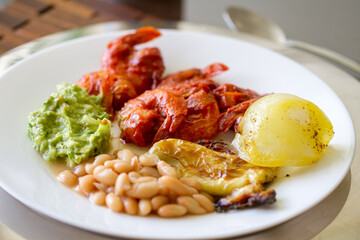 Typical Mexican dish for a lunch made of spicy chicken, guacamole, beans and potato