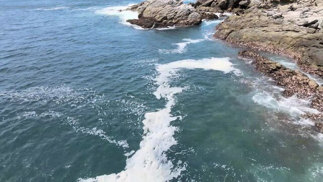 Pull back above  rocks and waves  in Oaxaca, Mexico