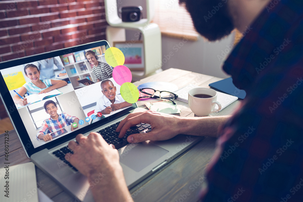 Canvas Prints Caucasian man using laptop for video call, with smiling diverse elementary school pupils on screen