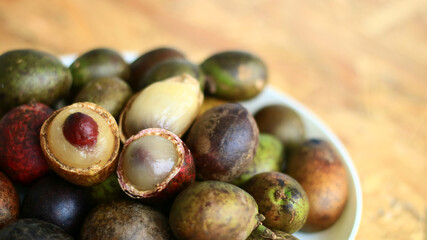 Matoa fruits or Pometia pinnata on wood background.