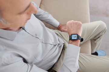 Mature man talking to his doctor via application on smartwatch