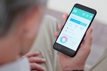 Close-up image of senior man checking micronutrient chart and consumed calories on smartphone