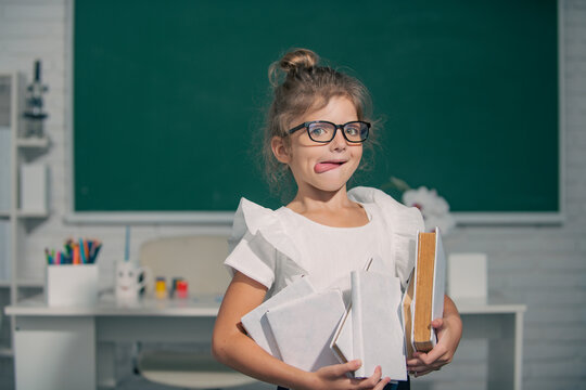 Cute funny child with tongue studying in classroom at elementary school. Elementary school and primary education.