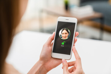 Woman scanning your face to unlock on smartphone, security and identification technology concept.