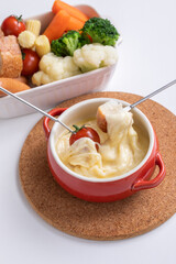 チーズホンデュとカラフルな蒸し野菜　
 パーティー料理が並ぶ白いテーブル