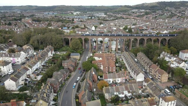 Train crossing viaduct on Southeastern line Folkestone Kent UK Aerial 4k footage