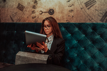 Business woman in glasses sitting in a modern cafe and preparing laptop for work. Selective focus