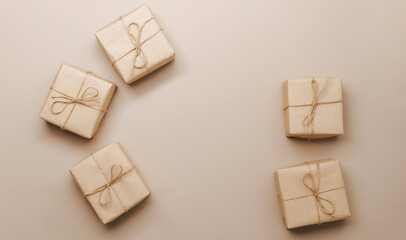 Gifts in eco-friendly paper packaging on a trendy beige background. Layout mockup copy space concept minimalism