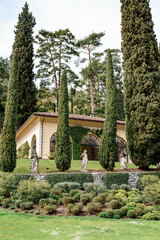 Fototapeta na wymiar Tall cypress trees in the park at Villa Balbianello. Lake Como, Italy