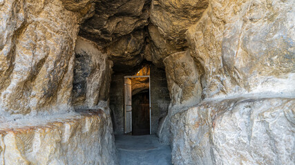 A narrow tunnel leads to the entrance to the pyramid of Cheops. Ancient stone walls close-up. The...