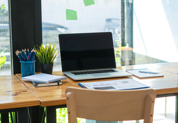 Front view of mock up laptop on table in office and background in the coffee shop.