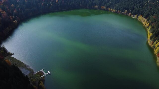 Quiet And Beautiful View Of The Saint Anna Lake Located At a Volcano Crater In Romania - aerial shot