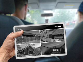 Man riding in taxi and watching security camera on tablet screen