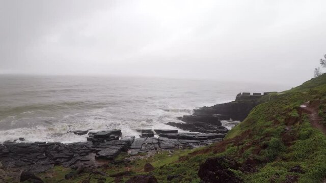 Devil's eye goa in monsoon. It is also known as devil's finger near Sinquerim Fort to Lower Aguada. Water waves crash into rocks and Sea foam creating amazing shapes and patterns