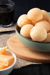 Traditional Brazilian cheese bread (pão de queijo) in a green bowl .