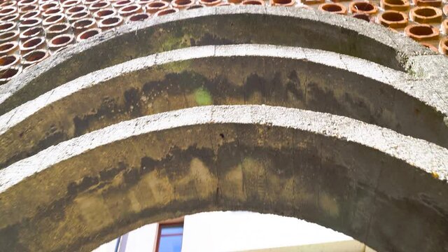 Creative architecture of a concrete Arch in a Wall with Circular terracotta holes, gimbal tilt-up