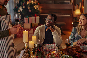 Diverse friends having lunch together at a table during Christmas time