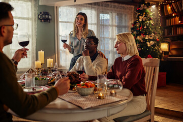 Friends having lunch together at a table during Christmas time