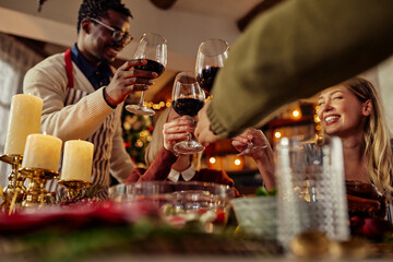 Diverse celebrating Christmas and toasting with red wine