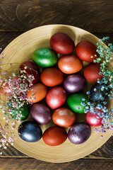 festive plate with Easter bright eggs and spring flowers. top view.