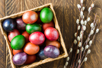 view from above of a wooden box with Easter colorful eggs and willow twigs. the concept of celebrating Easter.
