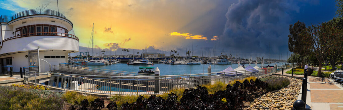 a stunning panoramic shot of the boats and yachts sailing in the harbor with deep blue ocean water and blue sky and powerful clouds at Burton Chace Park in Marina del Rey, California