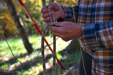 Midsection of man preparing rope for work in forest