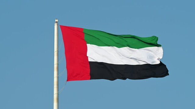 The Flag of the United Arab Emirates waving in the air,  The national symbol of The United Arab Emirate, 4k 60fps