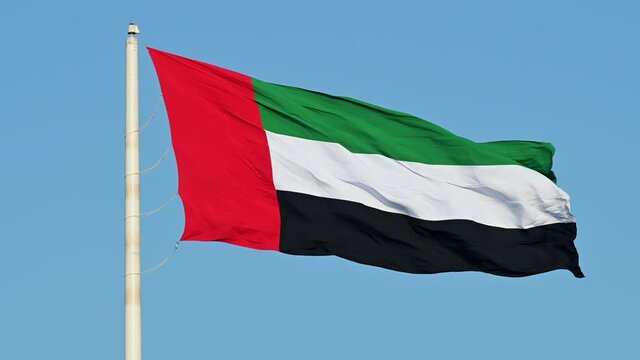 4k 60fps: The Flag of the United Arab Emirates waving in the air, the Blue sky in the Background, The national symbol of The United Arab Emirates