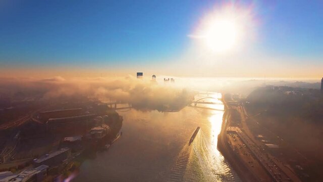 A fall sunrise in Pittsburgh with fog rising above the rivers