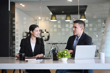 Two successful business people discussing project strategy at modern office.