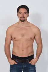 Fototapeta premium portriat of a man shirtless serious and hands on pocket on white background